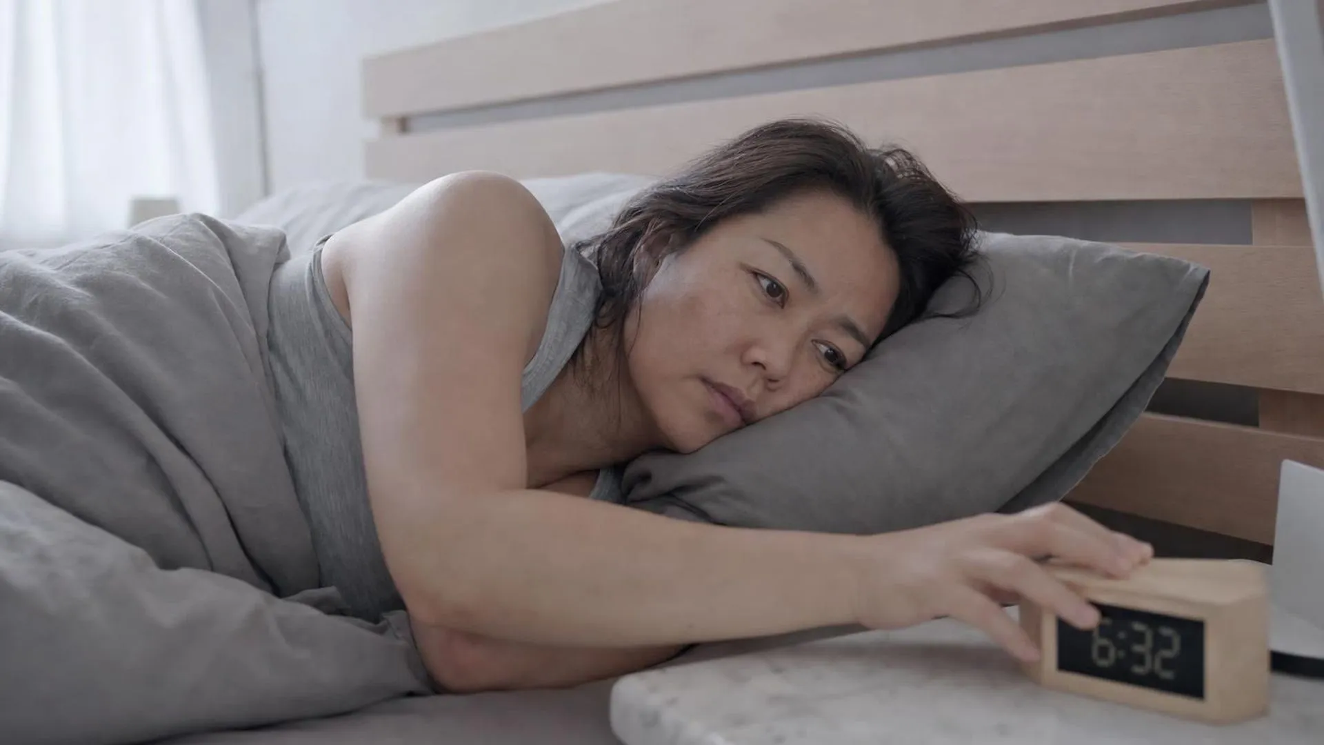 Iemand ligt bij het ochtendgloren wakker in bed en komt moeilijk overeind