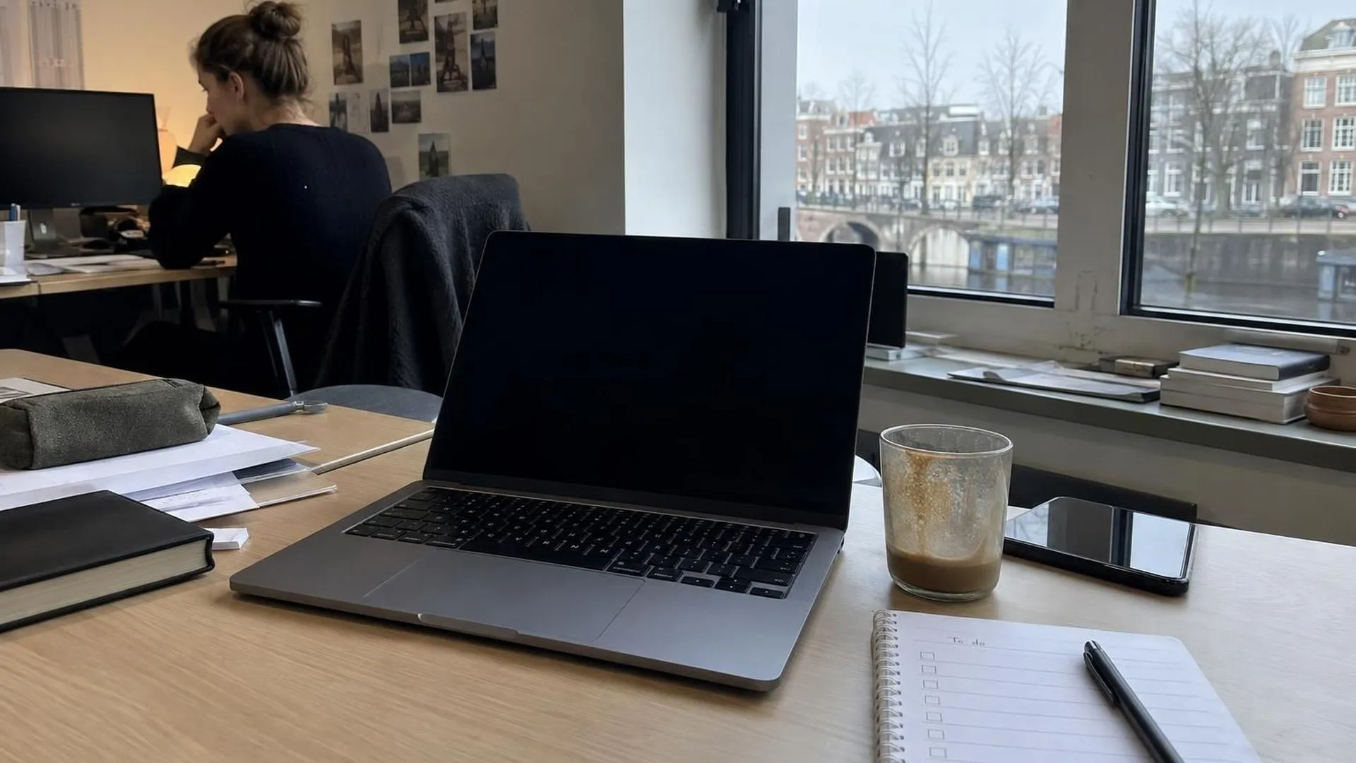 Een rommelig bureau met een laptop die in slaap is gevallen en een onaangeraakte to-dolijst
