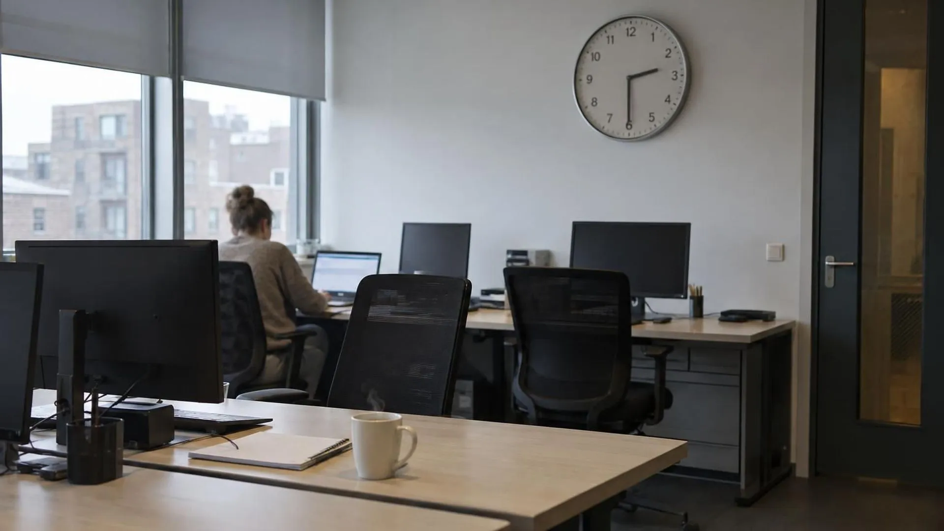 Een kantoorklok wijst half drie 's middags aan boven een rij bijna lege bureaus, het moment van de dag waarop de concentratie wegzakt.