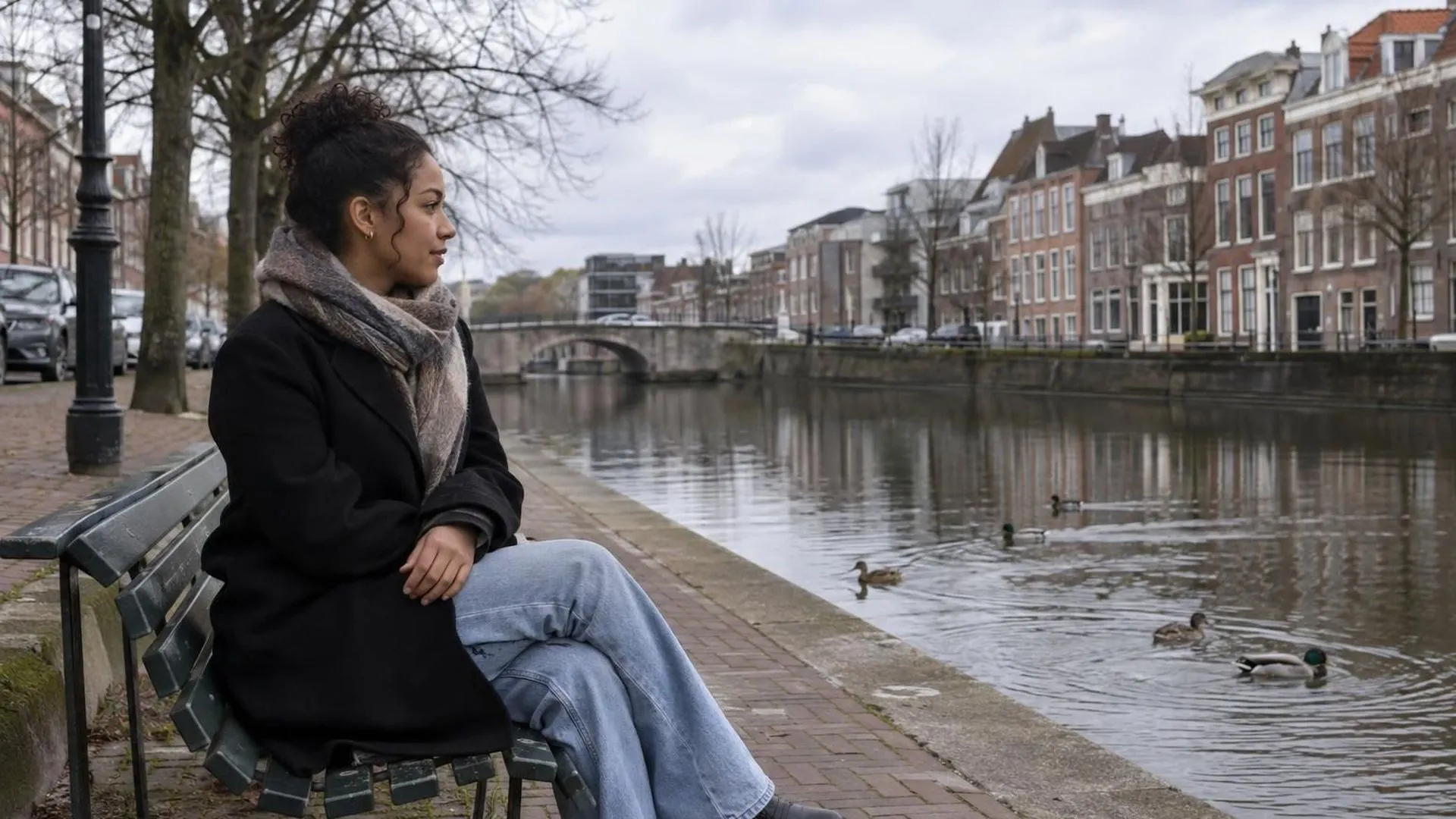 Iemand zit alleen op een bankje in het park op een vrije zaterdagochtend en kijkt naar de eendjes in de gracht