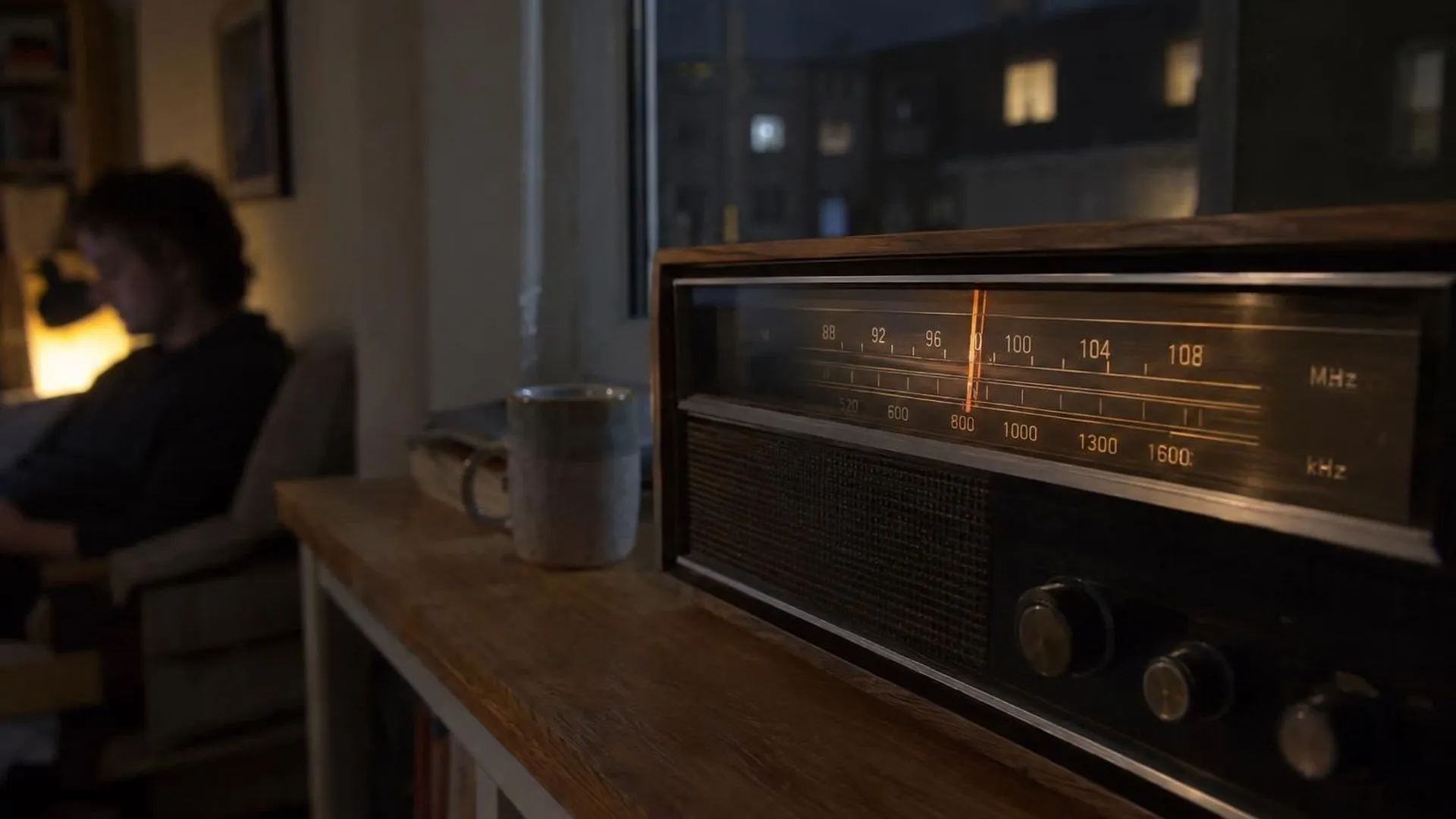 Een ouderwetse radio-afstemschaal die 's avonds tussen twee zenders in staat.