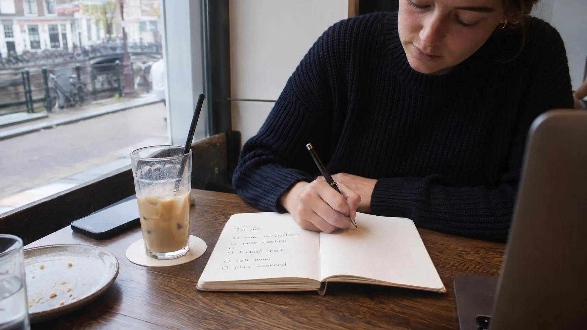 Opengeslagen notitieboek met een onafgemaakte to-dolijst naast een halfvolle, koude kop koffie