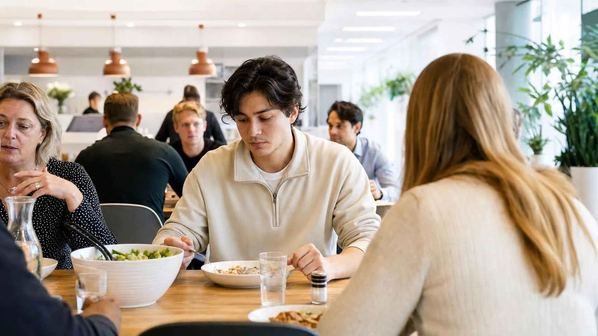 Persoon in gedachten verzonken aan een lunchtafel op het werk