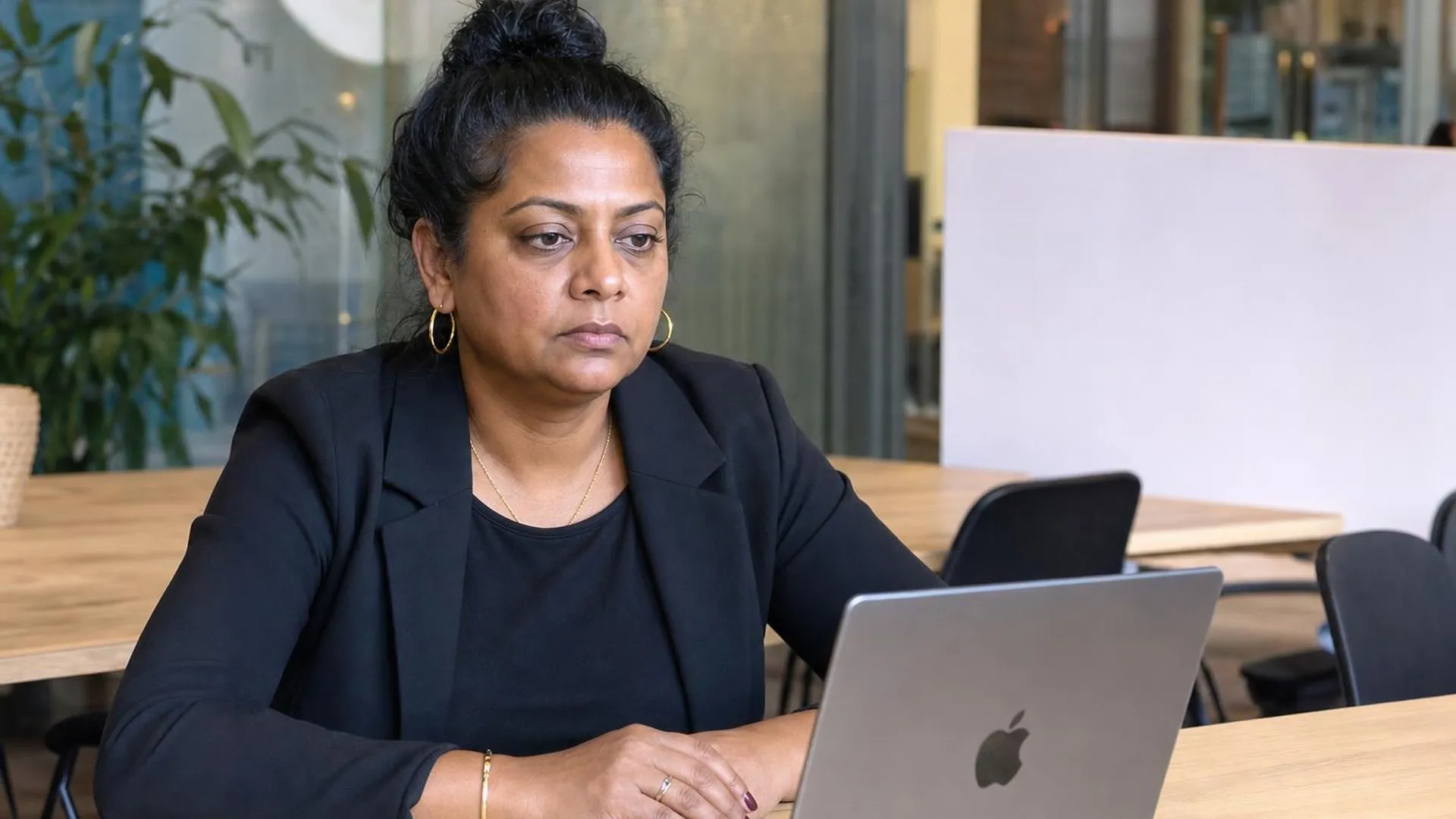 Persoon zit uitgeput voor laptop in een rustige werkomgeving