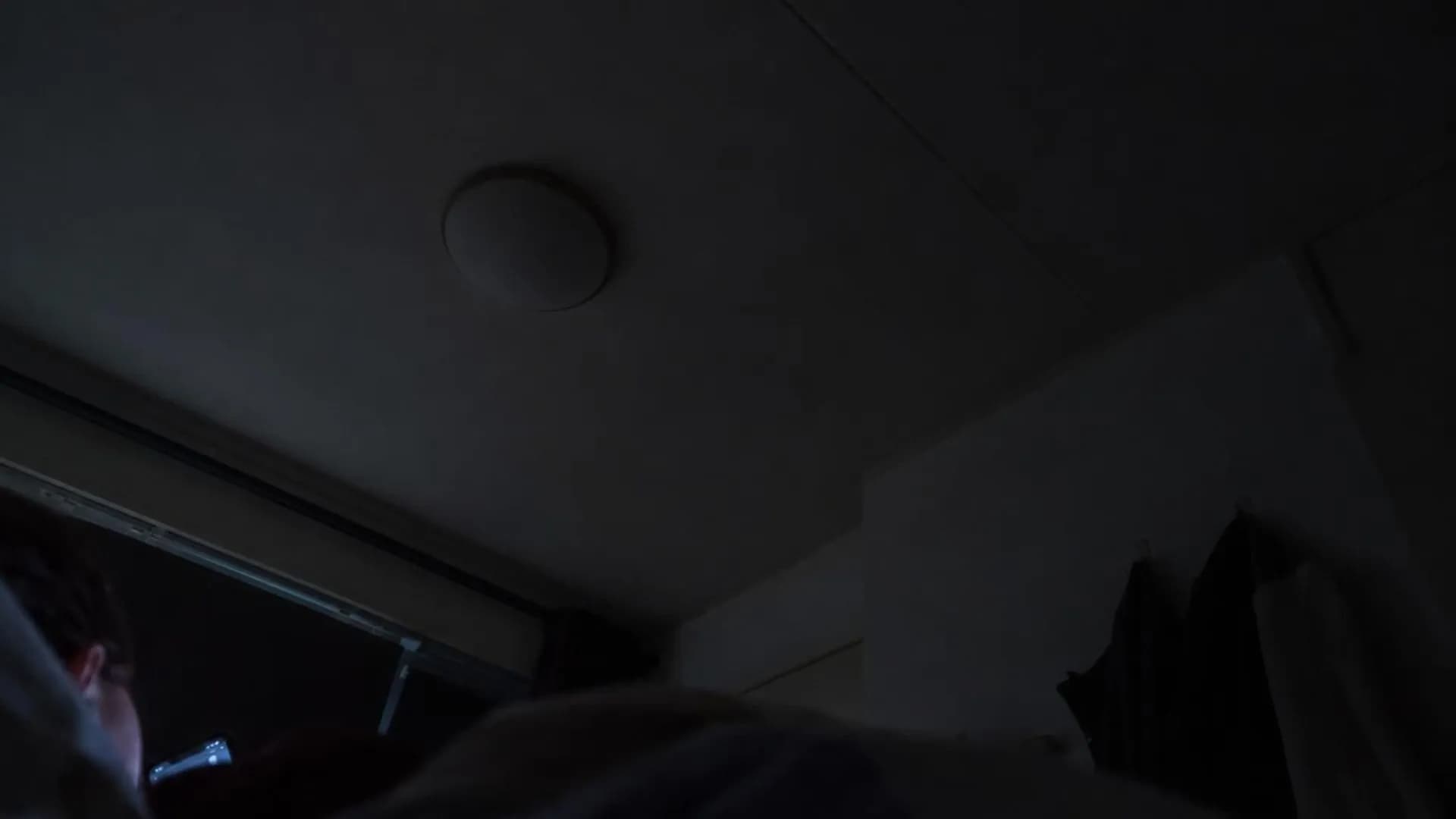 Vanaf het kussen gezien hangt om twee uur 's nachts een donker plafond boven je, met een vaag blauw schijnsel van een telefoon aan de rand van beeld.
