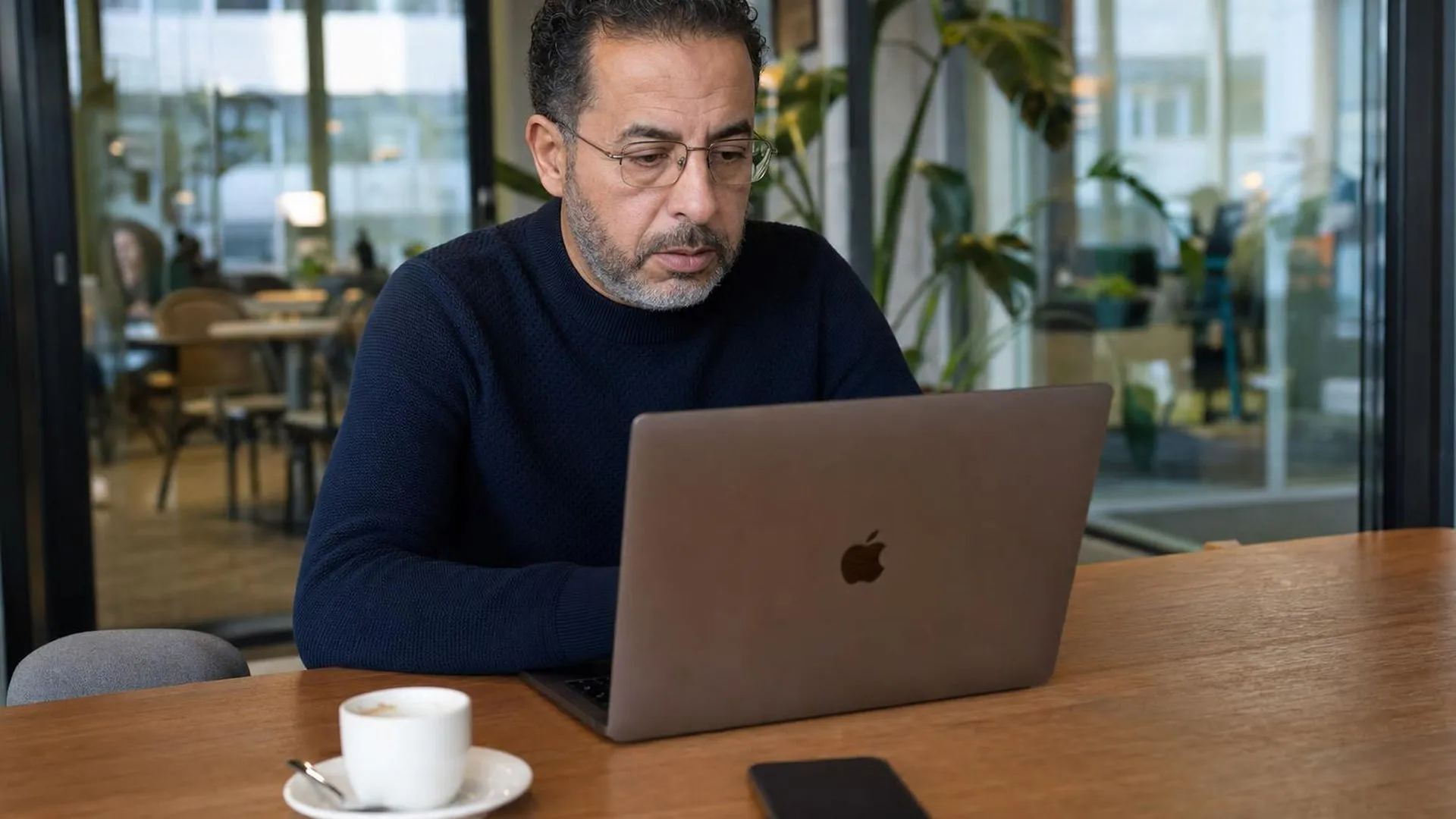 Persoon zit uitgeput voor laptop in een werkomgeving