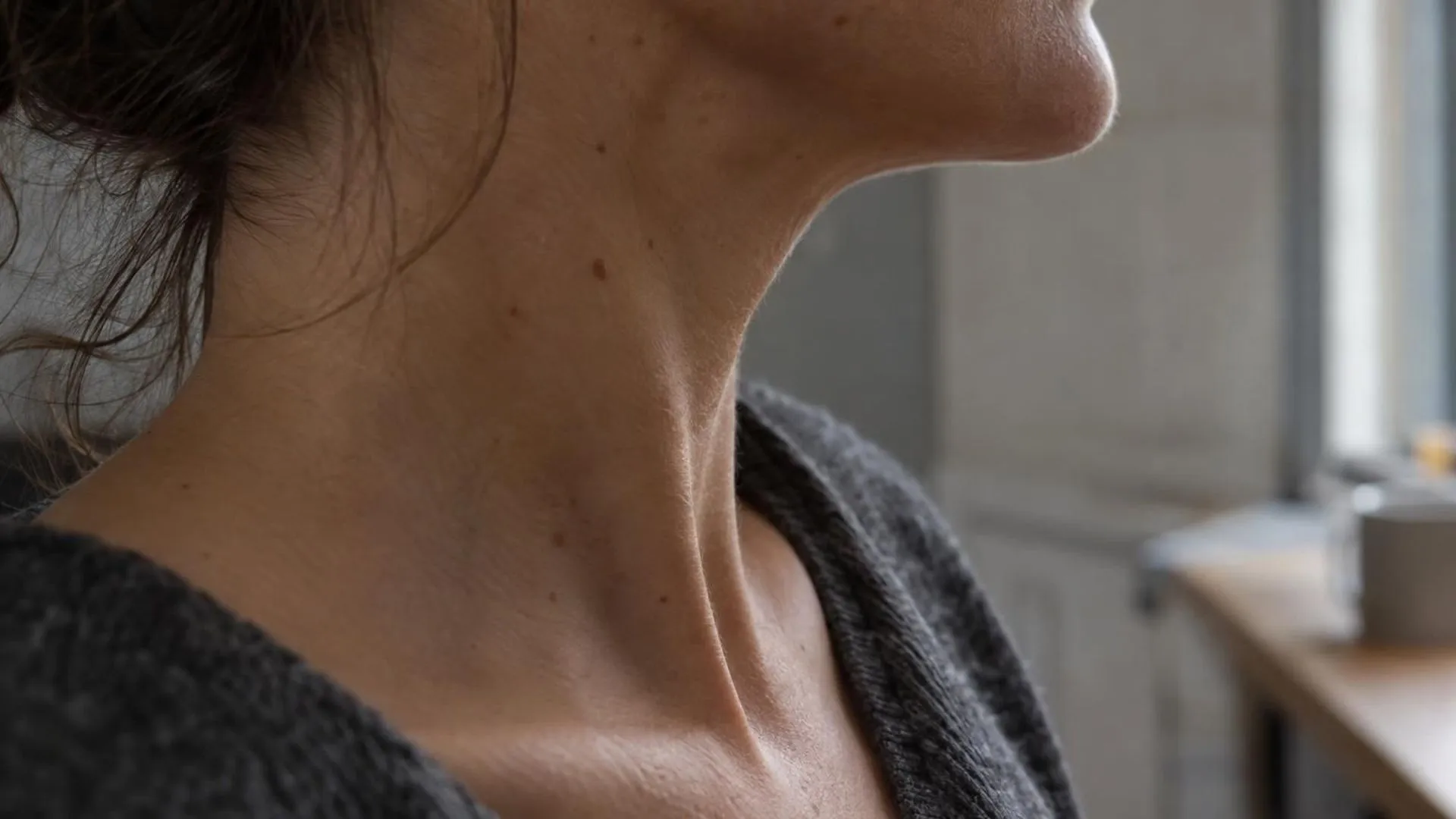 Close-up van de zijkant van een hals en keel in zacht licht